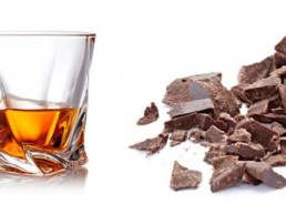 Bicchiere di rum con pezzi di cioccolato fondente.